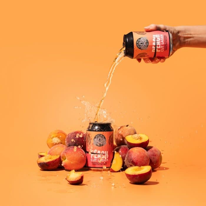 Peach lager being poured over Peach Cut Lager