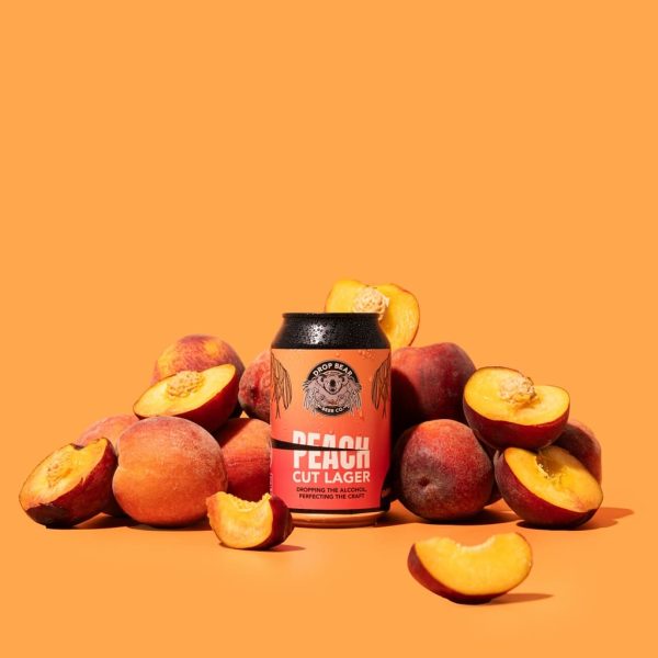 Peach lager surrounded by peaches.